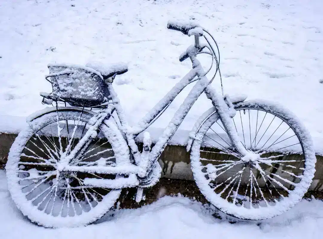Fiets volledig bedekt met sneeuw in een besneeuwd landschap