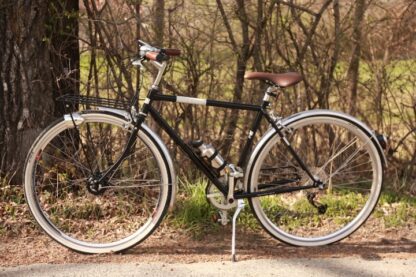 Chromen vintage fiets tegen een natuurachtergrond, onzichtbare elektrificatie in het voorwiel.