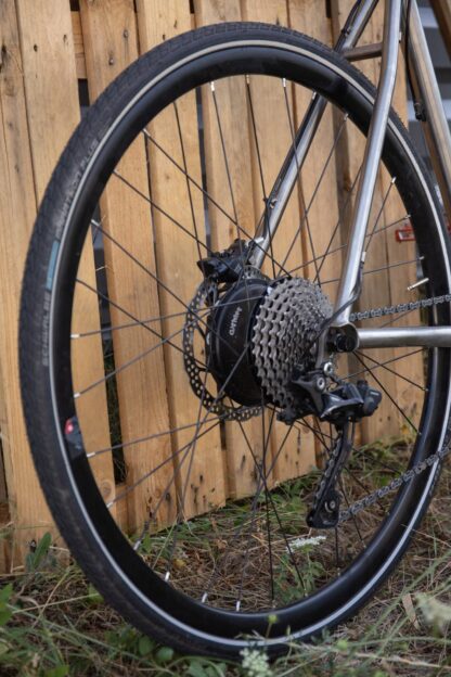 Motor met geïntegreerde accu gemonteerd op het achterwiel van een titanium gravelbike